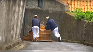 Ein Paar genießt eine traditionelle Korbschlittenfahrt
