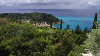 Das Dorf Agios Nikitas auf Lefkas umgeben von leuchtend grüner Natur und blauem Meer