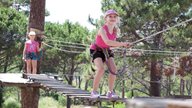 Zwei Kinder spielen in einem Klettergarten auf Korsika